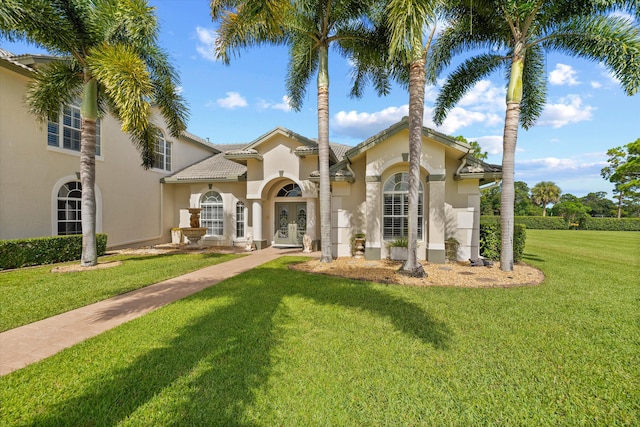 mediterranean / spanish home featuring a front lawn