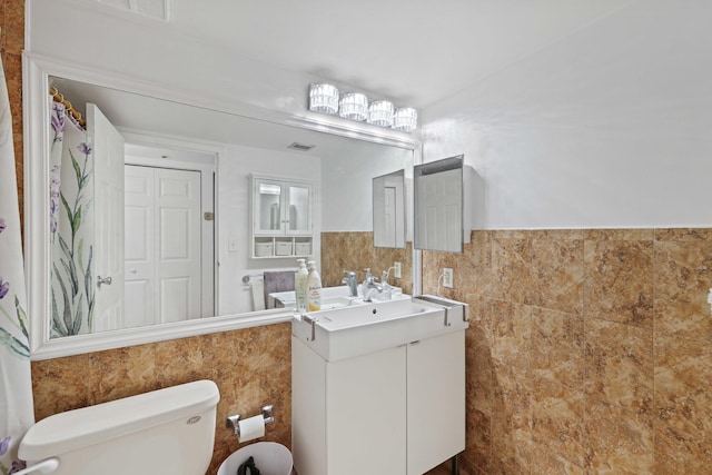 bathroom with tile walls, vanity, and toilet