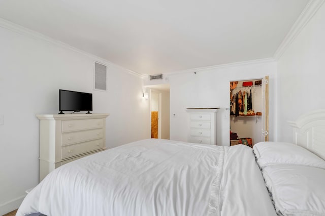 bedroom with a closet, ornamental molding, and a spacious closet