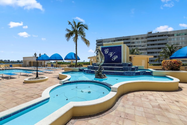 view of swimming pool featuring a community hot tub and a patio area