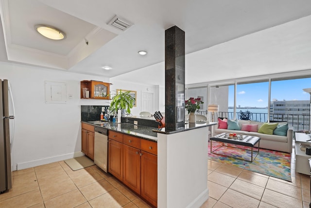 kitchen featuring dark stone counters, stainless steel appliances, kitchen peninsula, and light tile patterned flooring