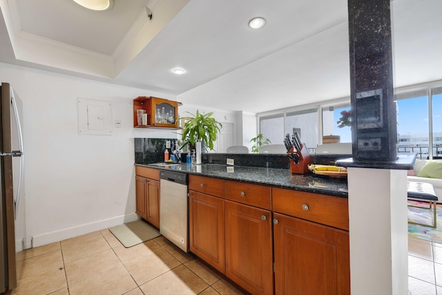 kitchen with dark stone counters, electric panel, kitchen peninsula, appliances with stainless steel finishes, and ornamental molding