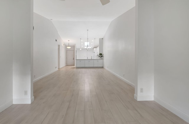 unfurnished living room with an inviting chandelier and light hardwood / wood-style flooring