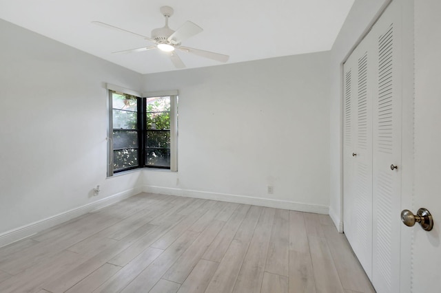 unfurnished bedroom featuring ceiling fan, a closet, and light hardwood / wood-style flooring