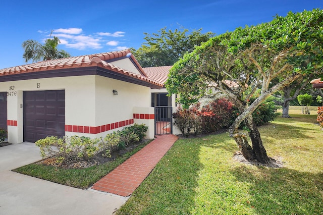 mediterranean / spanish house with a garage and a front lawn