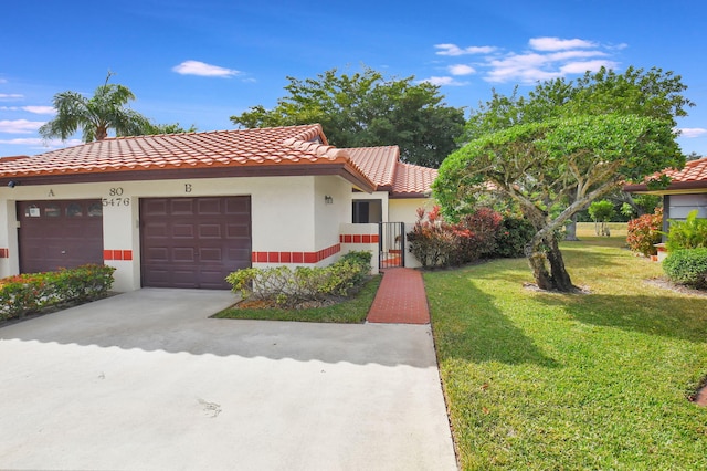 mediterranean / spanish home featuring a front lawn and a garage