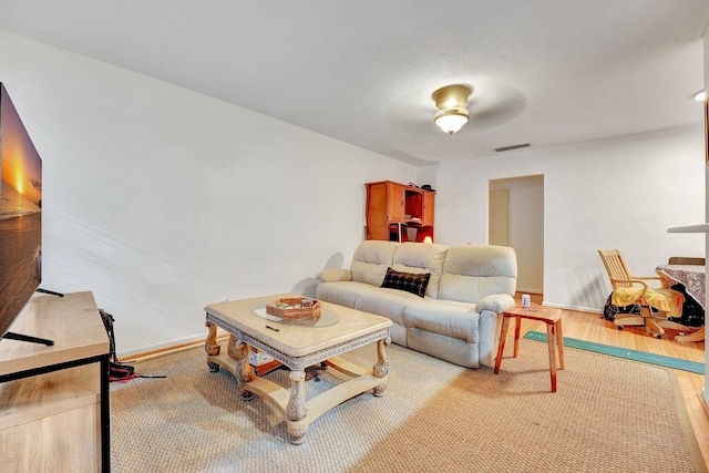 living room featuring ceiling fan and hardwood / wood-style flooring