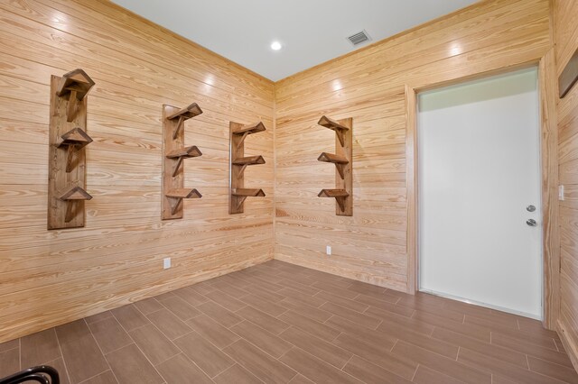 unfurnished room featuring wooden walls and dark wood-type flooring