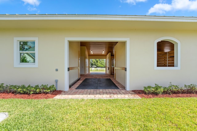 property entrance featuring a yard and a patio