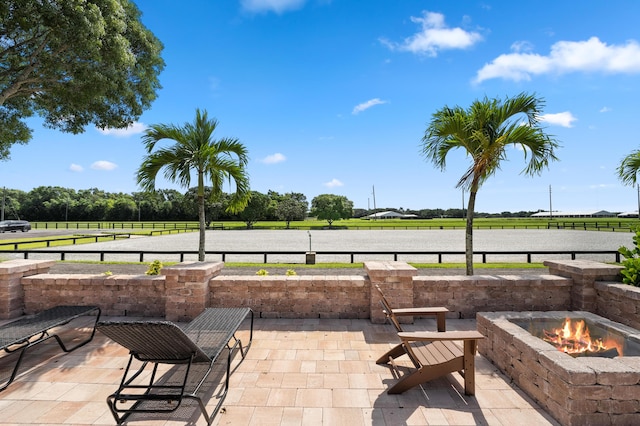 view of patio with a fire pit and a rural view