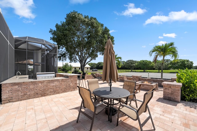 view of patio / terrace with a lanai and an outdoor kitchen