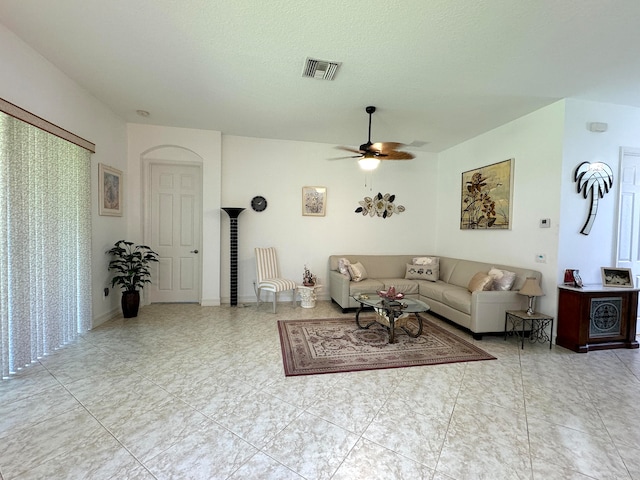 living room with a textured ceiling and ceiling fan