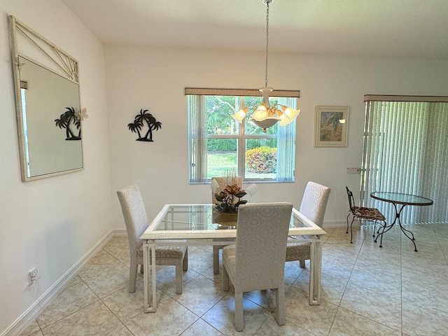 dining area featuring light tile patterned floors and a notable chandelier