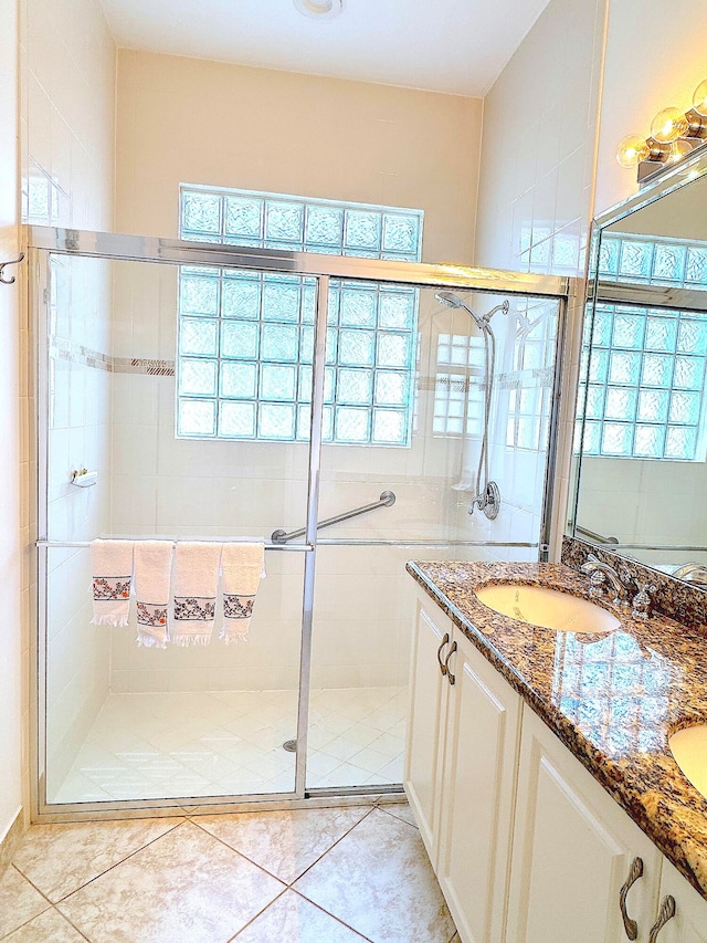 bathroom featuring a shower with door and vanity