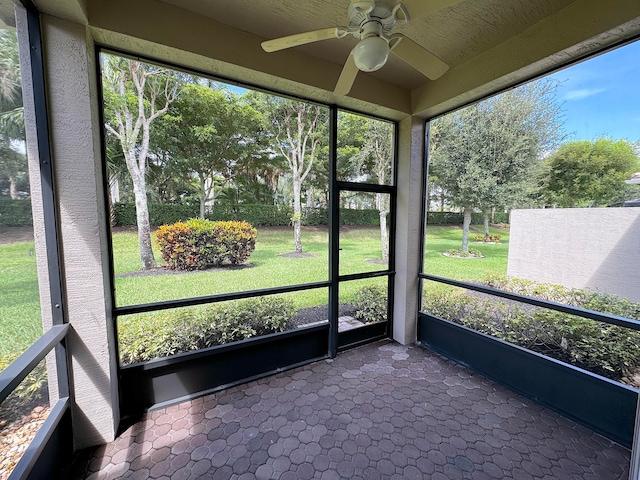 unfurnished sunroom with a healthy amount of sunlight and ceiling fan