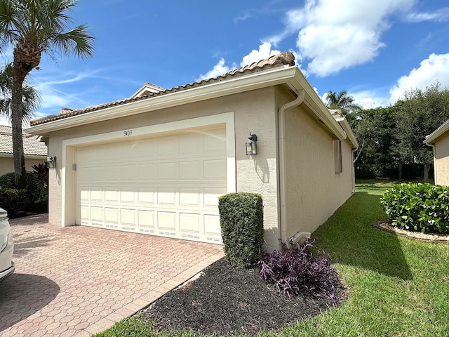 view of side of home with a lawn and a garage