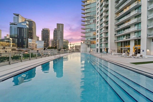 pool at dusk with a patio