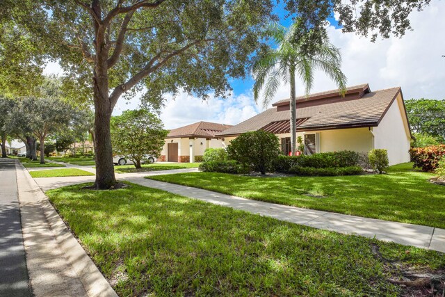 view of front of property with stucco siding and a front lawn