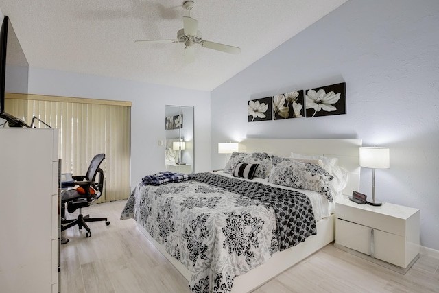 bedroom with ceiling fan, light wood-type flooring, a textured ceiling, and lofted ceiling