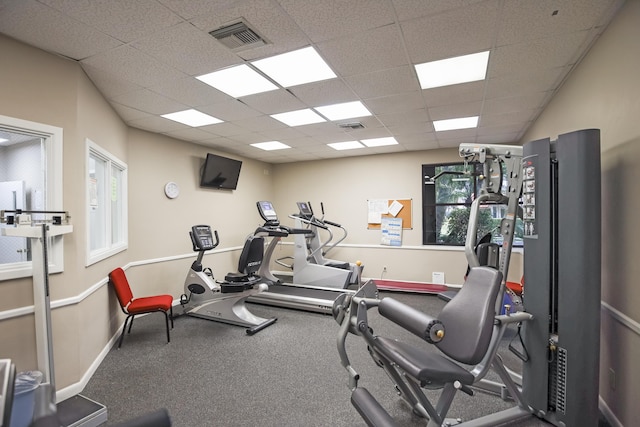 exercise area featuring a drop ceiling and plenty of natural light