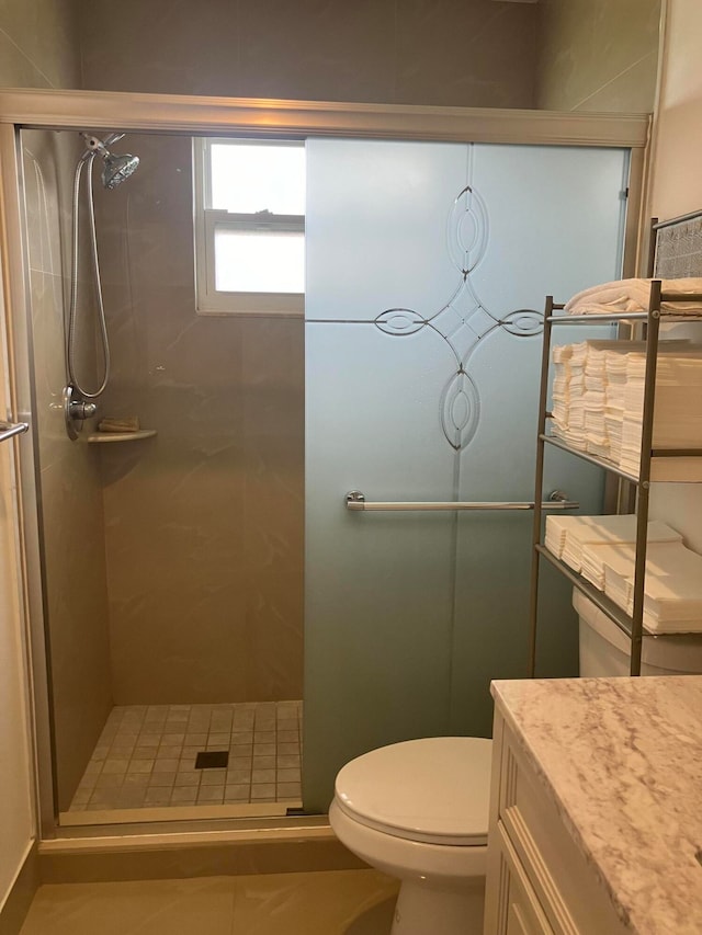 bathroom featuring a shower with shower door, toilet, and vanity