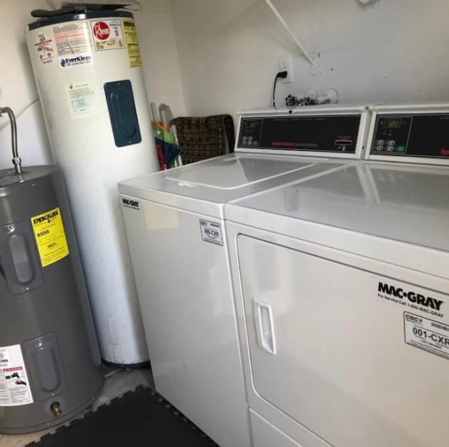 clothes washing area featuring water heater and washing machine and dryer