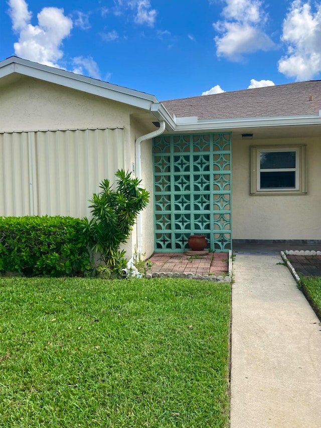 view of exterior entry with a yard