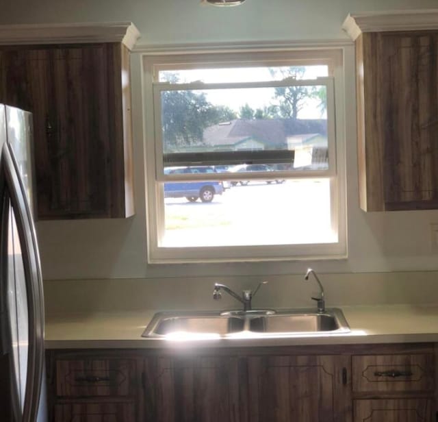 kitchen with plenty of natural light, stainless steel refrigerator, and sink