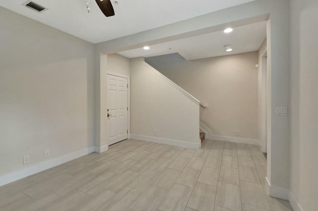 basement featuring light wood-type flooring and ceiling fan