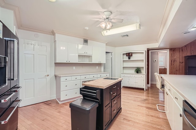 kitchen featuring ceiling fan, a center island, dishwasher, white cabinets, and light wood-type flooring