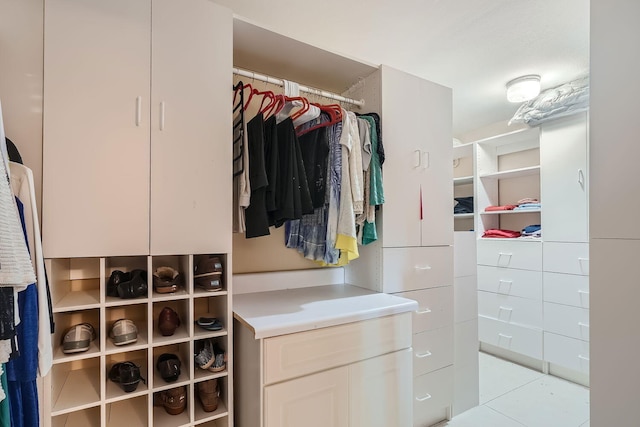 walk in closet with light tile patterned floors