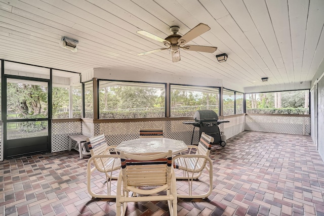 sunroom / solarium featuring ceiling fan and wood ceiling