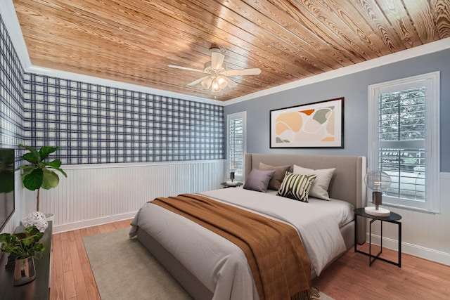 bedroom featuring hardwood / wood-style floors, ceiling fan, and multiple windows