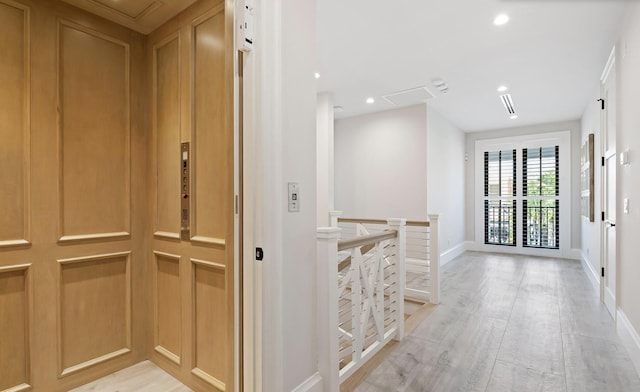 corridor with an upstairs landing, elevator, light wood-style flooring, baseboards, and recessed lighting