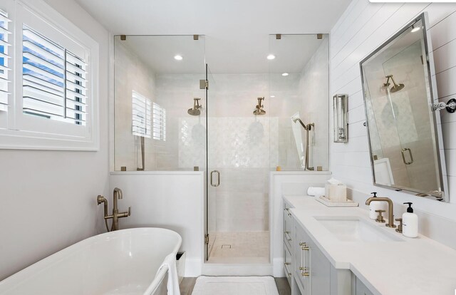 bathroom featuring a soaking tub, vanity, a stall shower, and recessed lighting