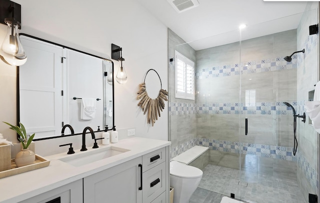 bathroom with visible vents, a stall shower, toilet, and vanity