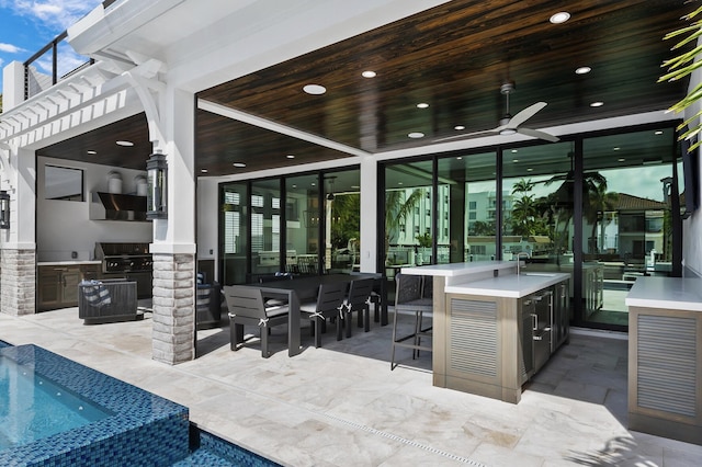 view of patio / terrace featuring exterior kitchen, a pool with connected hot tub, ceiling fan, a grill, and a sink