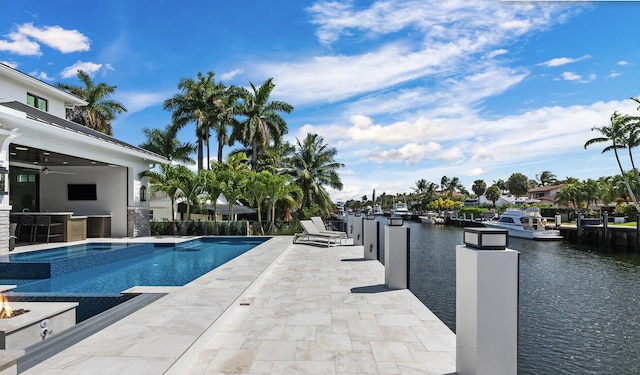 view of swimming pool featuring a pool with connected hot tub, a ceiling fan, a patio, outdoor dry bar, and a water view
