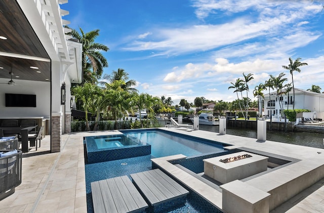 view of swimming pool featuring a fire pit, a pool with connected hot tub, ceiling fan, and a patio area