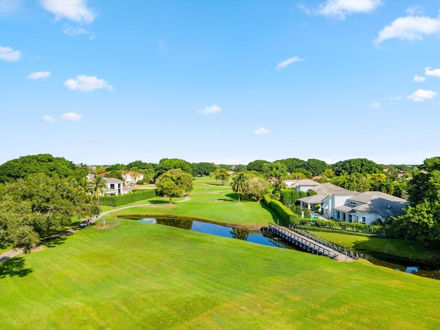 surrounding community with a water view and a yard