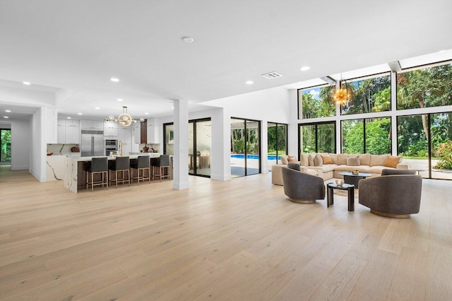 living room with a chandelier and light hardwood / wood-style flooring