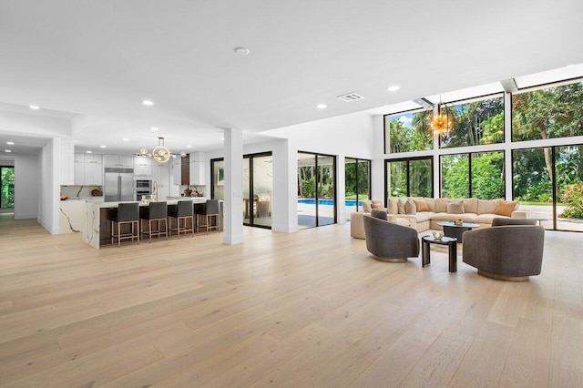 16436 Bridlewood Cir E, Delray Beach, FL 33445 - living room with light wood finished floors, a chandelier, recessed lighting, and baseboards
