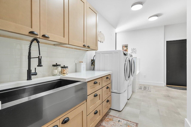 laundry area with cabinets, independent washer and dryer, sink, and light tile patterned floors