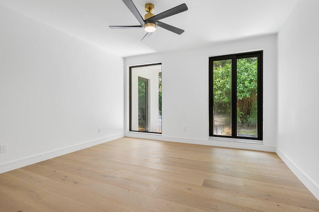 unfurnished room featuring a wealth of natural light, ceiling fan, and light wood-type flooring