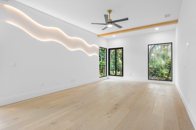 empty room featuring beamed ceiling, ceiling fan, and light wood-type flooring