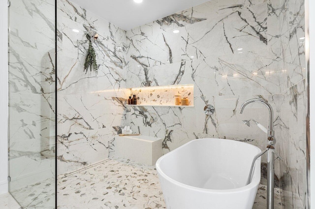 bathroom with a bathtub and tile walls