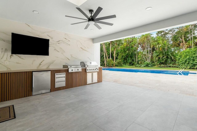 view of patio with a grill, ceiling fan, and exterior kitchen