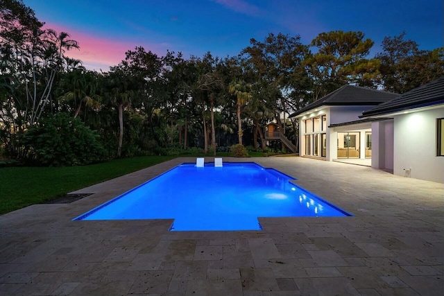 pool at dusk with a patio