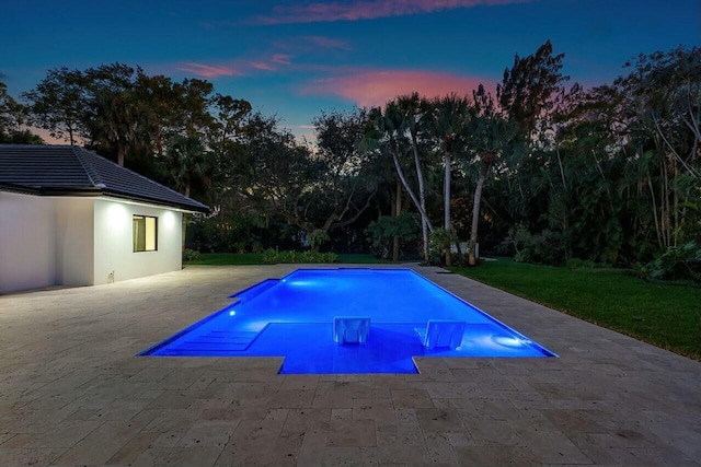 pool at dusk with a patio