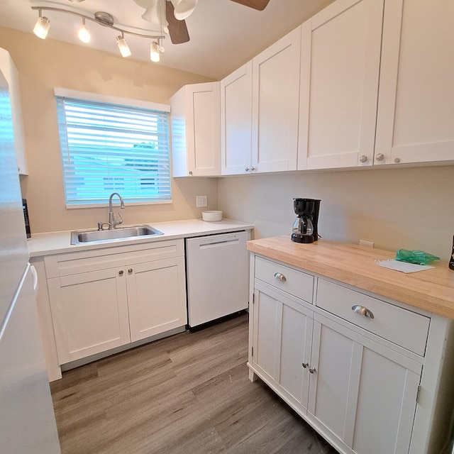 kitchen featuring a ceiling fan, a sink, wood counters, white dishwasher, and light wood finished floors